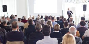 Audience in the lecture hall. Speaker Giving a Talk at Business Meeting. Audience in the conference hall. Business and Entrepreneurship. Panoramic composition suitable for banners.